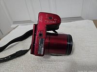 Bottom view of Nikon Coolpix L840 red camera with strap attached