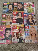Seven of the nine TV Guide magazines laid out showing covers with Shania Twain, Sophia Loren, Marcia Cross and others
