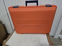 Front of orange Construx Fisher-Price case with blue handle