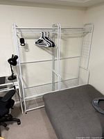 Both white metal clothing racks assembled beside each other