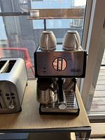 Front view of DeLonghi ECP3420 machine with accessories visible