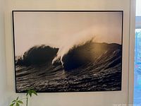 Front view of framed ocean wave photograph hanging on wall