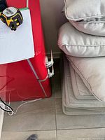 Partial side view of red retro fridge showing chrome handles and adjacent items