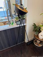 Full view of tripod floor lamp beside counter
