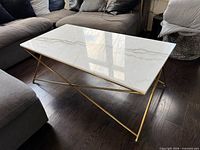 Full view of coffee table showcasing marble top and gold base