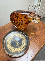 Amber art-glass moose beside round letter Y paperweight