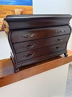 Front view of closed Bombay three-drawer jewelry box showing overall design and condition