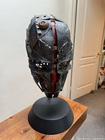 Front three-quarter view of mask on stand