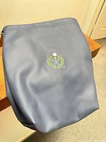 Front view showing blue bag and embroidered golf motif