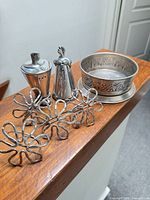 Group shot of wine holder, salt & pepper shakers, four flower napkin rings