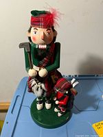 Front view of golfer nutcracker showing attire and attached golf bag