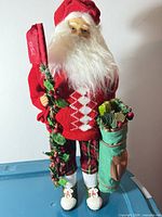 Full view of Santa golfer figure standing on blue surface