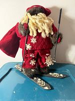 Full view of Santa figurine on skis leaning against wall
