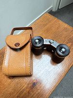 Opera glasses beside leather case