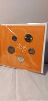 Front view of sealed 2015 orange gift set showing all five coins