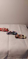 Three die-cast NASCAR cars lined up on table
