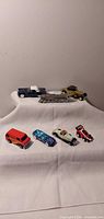 overview of seven die-cast vehicles on cloth backdrop