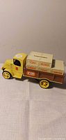 Full view left side of yellow ERTL Mack bank truck with crates