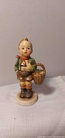 Front view of Goebel Hummel Village Boy figurine on round base