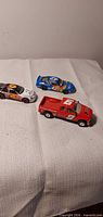 Three die-cast vehicles on cloth surface