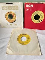 Three 7-inch records in sleeves