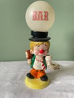 Front view of ceramic clown bartender lamp with globe shade marked "BAR"