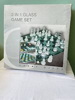 Front of sealed box showing 3-in-1 glass game set contents