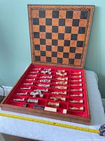 Open case showing board surface, storage tray with gold and silver pieces and round discs