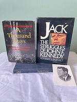 Front view of three hardcover books and memorial card