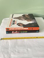 Two books stacked with measuring tape for scale