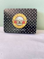 Closed tin showing Guns N’ Roses logo and suit symbols
