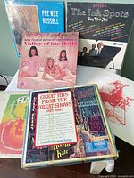 Front view showing six vinyl records including Pee Wee Russell, Valley of the Dolls, Ink Spots, Great Hits box set and two unidentified LPs