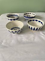 Top view of four ceramic bowls showing varied blue geometric patterns
