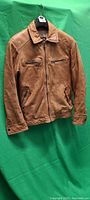 Full front view of tan leather jacket on hanger