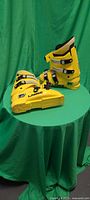 Full view of both yellow Lange ski boots on table