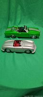 Both model cars side by side on green background