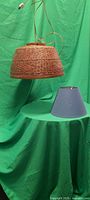 Wicker pendant light hanging above blue lampshade on table