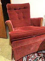 Front angle of red velour accent chair with tufted back and skirted base