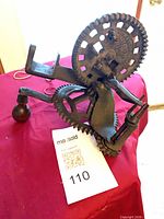 Overall view of cast iron apple peeler showing large gear and crank