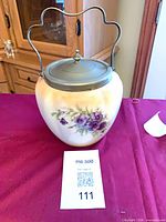 Front angled view of biscuit jar showing floral decoration and lid