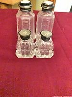 Front view of four shakers on red surface