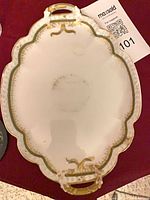 Top view of scalloped handled porcelain platter showing green and gold trim