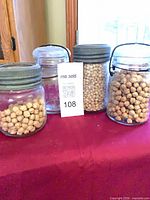 Front view of four glass sealing jars showing lid types and contents