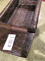 Overall view of antique wooden sled body showing hollow compartment and aged surface