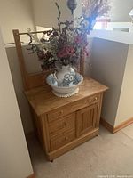 Washstand with basin, pitcher and floral arrangement in setting