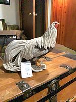 Front-left view of rooster figurine showing body and head