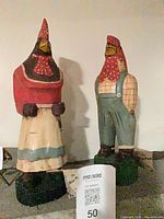 Both carved wood chicken figures side by side