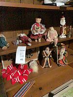 Shelf displaying all resin figurines, knit stockings and plush ornament