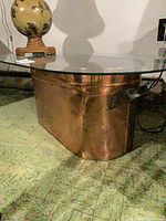 Copper boiler base supporting glass top table