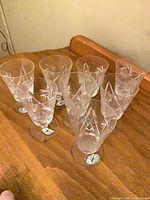 Eight crystal liqueur glasses grouped on wooden surface